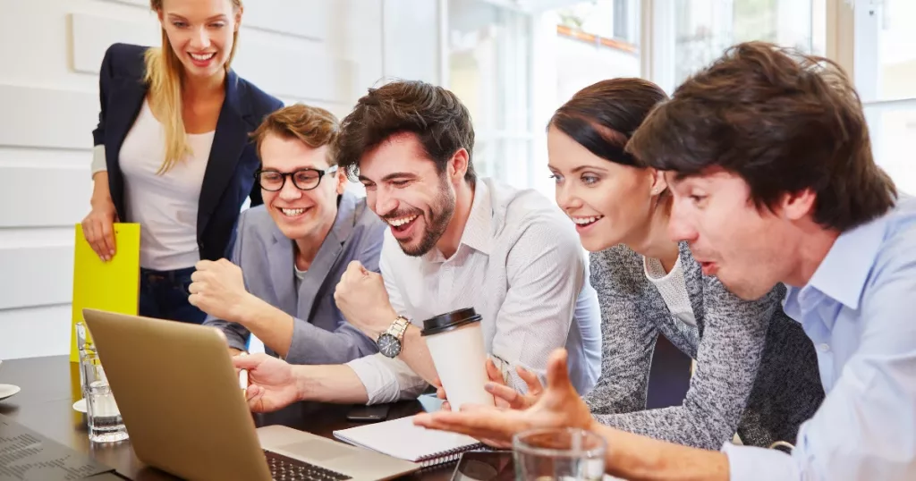 a group of digital marketers looking at laptop screen on the table