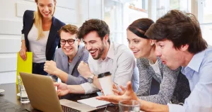 a group of digital marketers looking at laptop screen on the table